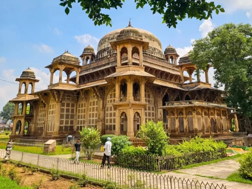 Tomb of Mohammad Ghaus in Gwalior showcasing Indo-Islamic architecture with carved stone screens, domed pavilion, and landscaped gardens, a historic monument included in Madhya Pradesh tour packages