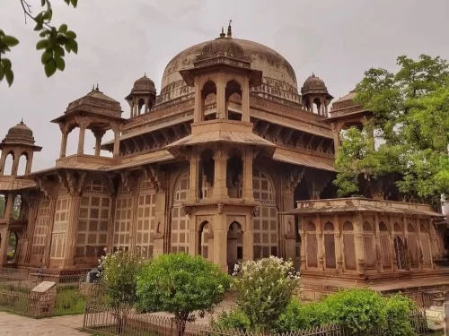 Tomb of Tansen in Gwalior featuring elegant Mughal-era architecture with domed pavilion and carved stone latticework, a cultural landmark included in Madhya Pradesh tour packages