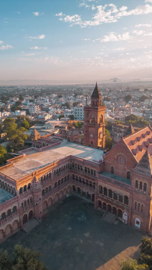 Aerial view of historic Prag Mahal in Bhuj Gujarat showcasing red sandstone architecture and cityscape backdrop included in Gujarat tour packages