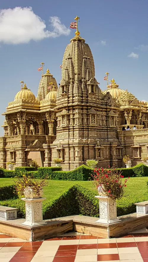 Intricately carved temple in Jamnagar Gujarat with golden domes and detailed stone architecture surrounded by manicured gardens included in Gujarat tour packages