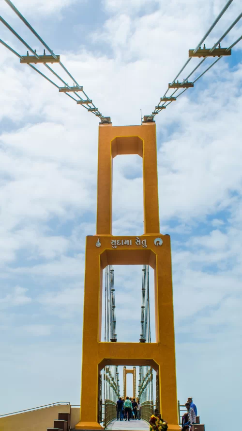 Sudama Setu suspension bridge in Somnath Gujarat with visitors walking under bright blue sky a popular attraction included in Gujarat tour packages