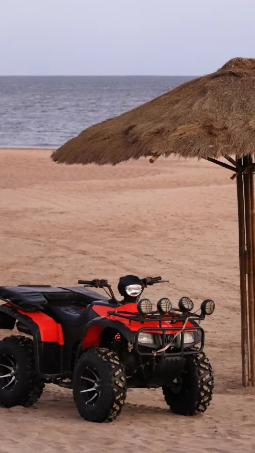 ATV bike parked on the sandy beach in Daman and Diu Gujarat near a seaside shack offering adventure activities included in Gujarat tour packages