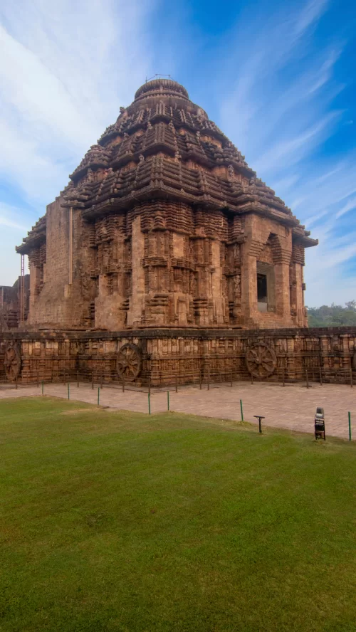 Side view of Konark Sun Temple in Odisha with intricate stone wheels and ancient carvings featured in Odisha tour packages