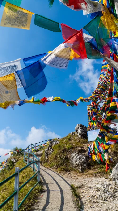 Mussoorie hilltop viewpoint with colorful prayer flags featured in Uttarakhand tour packages