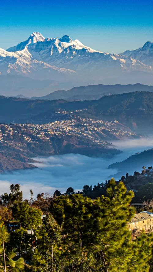 Nainital panoramic Himalayan mountain view with snow-capped peaks, misty valleys, and scenic hill town landscape in Uttarakhand tour packages