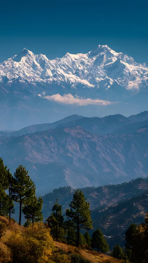 Breathtaking panoramic view of the snow-capped Nanda Devi and Trishul peaks from Kausani, Uttarakhand, with lush green valleys—a scenic gem in Uttarakhand tour packages.