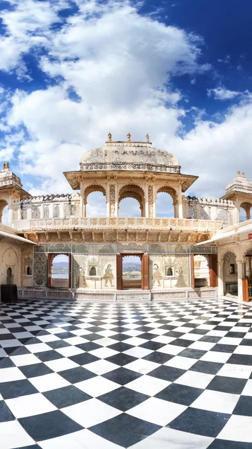 City Palace Udaipur Rajasthan during clear day, featuring marble arches and courtyard patterns, perfect heritage experience Rajasthan tour package