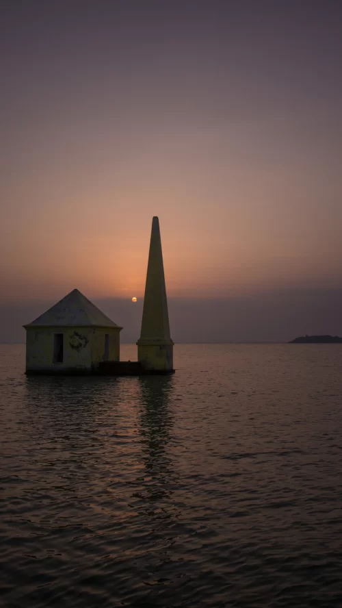 Sunset view of temple structure in Chilika Lake Odisha with calm waters and glowing sky featured in Odisha tour packages