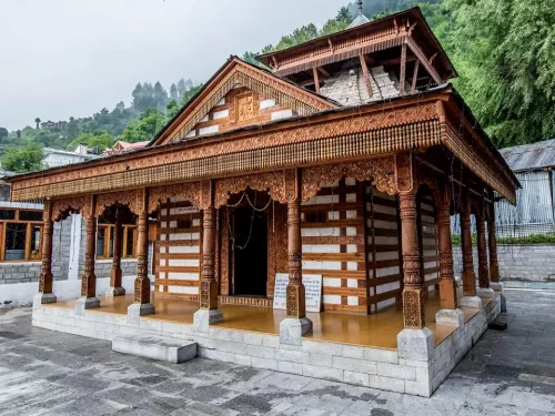 Vashishtha Temple at Manali Himachal Pradesh during misty weather, featuring carved wooden pagoda architecture and deodar forests, perfect spiritual experience Himachal Pradesh tour package.