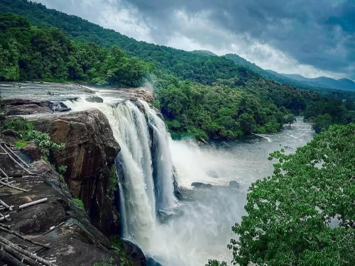 Vazhachal Waterfalls in Kerala, powerful cascades flowing through lush green forest landscape.