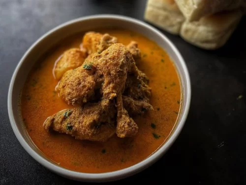 Chicken xacuti cooked in a thick, aromatic coconut and spice gravy, reflecting the bold and earthy flavors of traditional Goan cuisine.