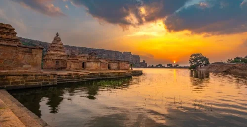 Agastya Lake in Badami during sunset, featuring serene lake, ancient temples and sandstone cliffs, perfect heritage experience, Karnataka tour packages.