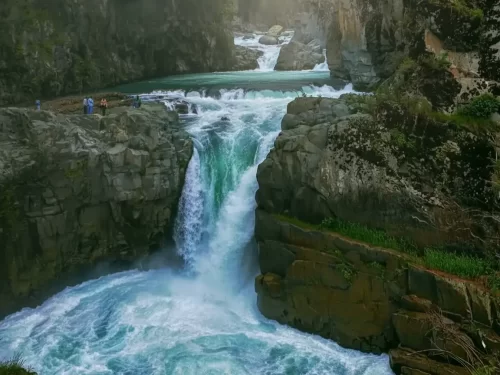 Majestic Aharbal Waterfall Kashmir emerald cascade gorge, tourists viewing roaring rapids rocky cliffs lush greenery, perfect Jammu Kashmir nature waterfall adventure package