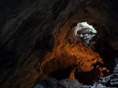 Borra Caves skylight interior near Vizag during day, featuring dramatic rock opening sunlight shaft, perfect adventure Araku Valley Andhra Pradesh tour package.
