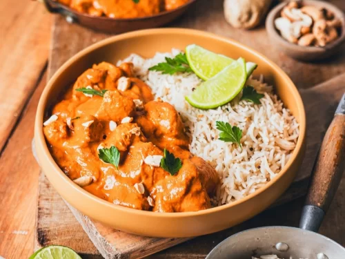 Butter Chicken in rich creamy tomato gravy with cilantro garnish, authentic Indian Punjabi curry, steaming hot delight.