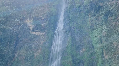 Siko Dido Waterfall in Shi Yomi district featuring majestic cascading streams down lush, green-covered cliffs, perfect Arunachal Pradesh tour package experience.