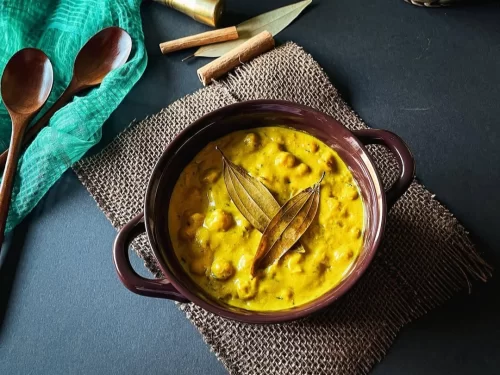 Chana Madra in creamy yogurt chickpea curry with bay leaf garnish, authentic Indian Himachali Brahmin dish, steaming hot delight.