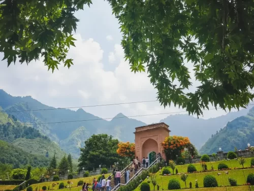 Chashme Shahi Srinagar Mughal Garden pink arch entrance terraced gardens Zabarwan mountains visitors trees flowers featured in Kashmir tour packages