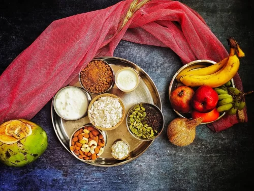 Chuda mix platter with flattened rice, jaggery, nuts, yogurt, fruits and banana garnish, authentic Indian Bihari snack, steaming hot delight.