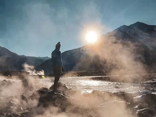 Chumathang Hot Springs Ladakh Indus River sunset steam hiker, snowy Zanskar peaks golden light rocky banks, perfect Leh Tso Moriri therapeutic geothermal package. 