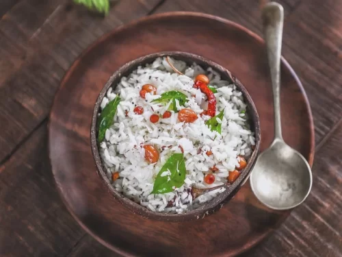 Coconut Rice in aromatic coconut milk gravy with peanut and curry leaf garnish, authentic Indian South Indian pulao rice, steaming hot delight.