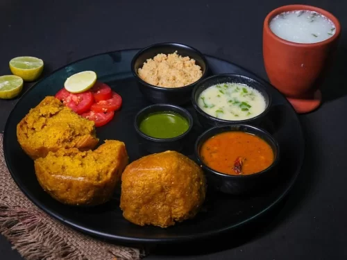 Dal Bafla in lentil dal gravy with pumpkin fritters, tomato chutney, lime garnish and lassi, authentic Indian Malwa platter, steaming hot delight.