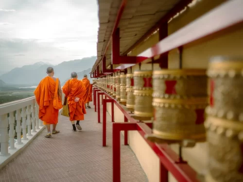 Diskit Gompa Ladakh orange robed monks prayer wheels red balcony Shyok Valley mountains Nubra backdrop, perfect Leh Ladakh spiritual adventure package.