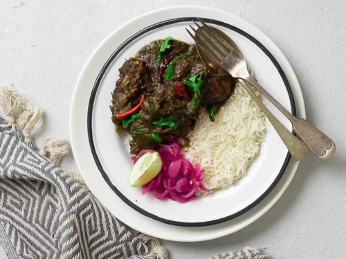 Dohneiiong in black sesame pork curry with rice, lime pickle garnish, authentic Indian Meghalayan Khasi tribal dish, steaming hot delight.