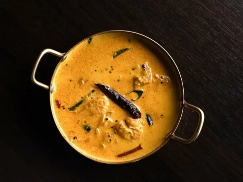 Sunset at Goa beach during evening, featuring palm trees and boats, perfect romantic experience Goa tour package.