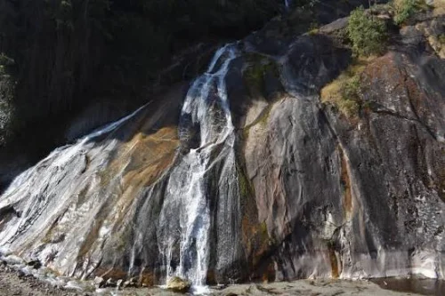 Matu Waterfall near Mechuka featuring cascading streams over smooth rocky cliffs, perfect Arunachal Pradesh tour package experience.