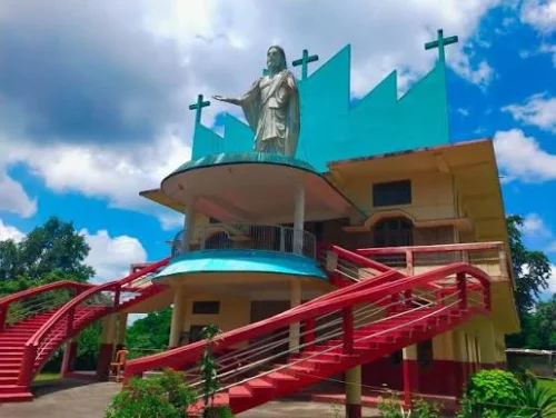 Catholic Church of Roing featuring a Jesus statue, vibrant red staircases, and unique architecture, perfect Arunachal Pradesh tour package experience.