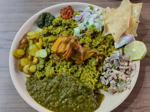 Jadoh in aromatic spiced rice with tender meat, onion cilantro garnish, authentic Indian tribal rice dish, steaming hot delight.