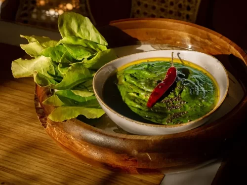 Kafuli in creamy spinach curry with mustard seeds and red chili, traditional Garhwali Indian green curry dish.