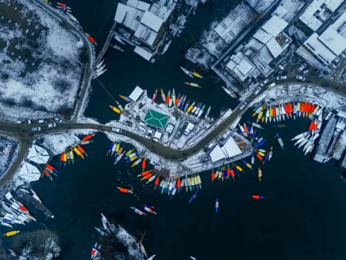 Aerial view of Dal Lake in Srinagar Kashmir with colorful shikaras and houseboats in winter, a vibrant highlight in Kashmir tour packages