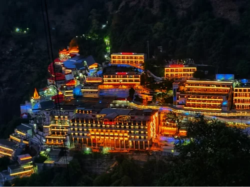 Vaishno Devi Bhawan Katra Jammu Kashmir night lights, featuring illuminated hotels temples cable car perched forested Trikuta mountains backdrop, perfect pilgrimage experience Jammu Kashmir tour packages.