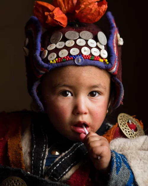 Traditional attire of a child in Dha Hanu village Ladakh showcasing local tribal culture, a unique cultural experience in Ladakh tour packages