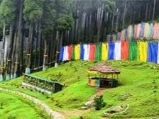 Lepcha Jagat in Darjeeling, West Bengal, featuring forested hillsides, colorful prayer flags, and peaceful walking trails, a serene mountain retreat included in West Bengal tour packages. 