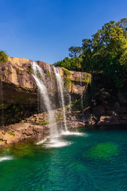 Krang Shuri Waterfalls in Meghalaya with crystal clear turquoise pool and cascading stream surrounded by greenery featured in Meghalaya tour packages