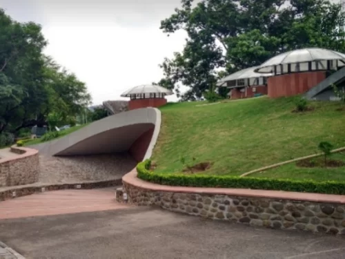 Nature Interpretation Centre in Kalimpong, West Bengal, featuring landscaped pathways, green lawns, and eco-friendly structures set amid forested surroundings, a key attraction included in West Bengal tour packages. 