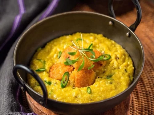 Phaanu in thick lentil curry topped with crisp fritters and green chilies, authentic Indian Garhwali cuisine with hearty comforting flavors.