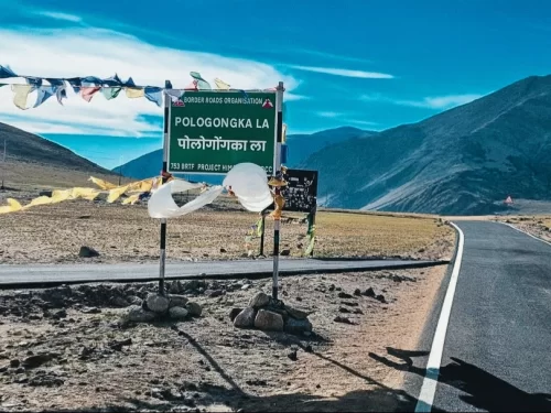Pologongka La high-altitude mountain pass BRO signboard fluttering prayer flags barren rugged mountains clear blue skies Ladakh India, scenic offbeat route Tso Moriri Tso Kar Leh-Manali highway adventure travel landmark.
