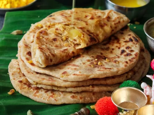 Puran Poli with soft wheat flatbread stuffed with sweet lentil filling, served warm on banana leaf, authentic Indian Maharashtrian festive delight.