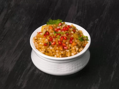 Sabudana Khichdi made with soaked tapioca pearls, peanuts, potatoes, and spices, garnished with pomegranate, authentic Indian fasting dish with light flavorful taste.