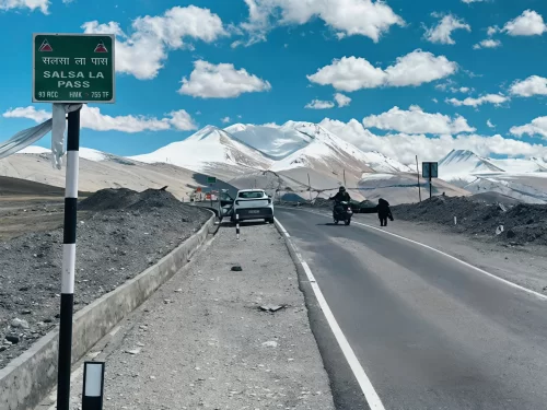 Salsal la pass signboard 4800m BRO vehicles bikers road snow-capped peaks blue skies gravel highway Ladakh India, newly opened 2025 Tso Moriri-Hanle route Changthang high-altitude adventure drive.