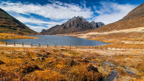 Sela Lake near Tawang featuring crystal-clear blue waters, rugged mountain peaks, and dramatic landscapes, perfect Arunachal Pradesh tour package experience.