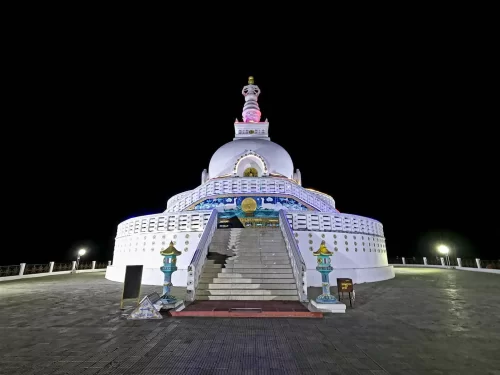 Shanti Stupa Leh night illuminated white stupa golden spire colorful lights staircase lamps dark sky, perfect Ladakh Himalayas spiritual tour package.