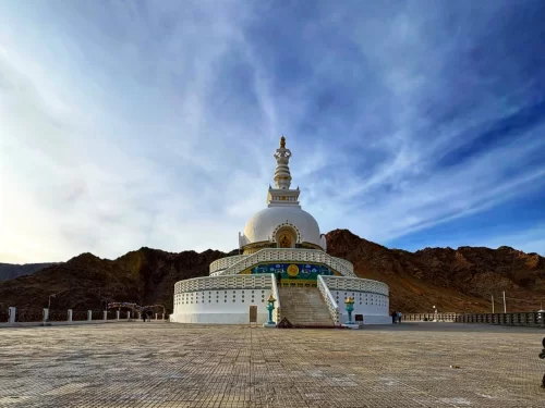 Shanti Stupa Leh panoramic view white stupa golden top blue skies Ladakh mountains plaza visitors, perfect Himalayas spiritual adventure tour package.