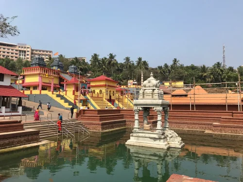 Shri Ananthapadmanabha Swamy Temple in Mangaluru during daylight, featuring sacred pond and traditional temple architecture, perfect spiritual experience, Karnataka tour packages.