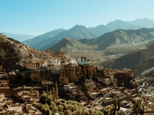 Panoramic view of Lamayuru Monastery perched on cliff along Srinagar Leh Highway Ladakh during clear sky day, featuring terraced white buildings rugged valley distant snow-capped mountains, perfect heritage road trip experience with Srinagar Leh Highway t