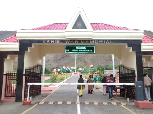 Drass War Memorial Ladakh Kargil War Memorial entrance gate tourists Indian flags LED sign red roof snowy mountains Operation Vijay tribute, perfect Ladakh heritage tour package.